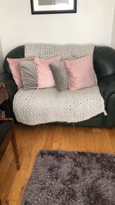 Green sofa with throw and cushions