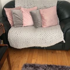 Green sofa with throw and cushions