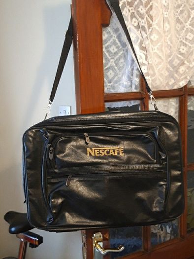 Nescafe shoulder cross bag. Travelling bag with suit case.