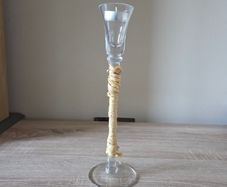A tall clear glass candle holder
