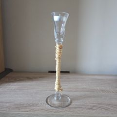 A tall clear glass candle holder