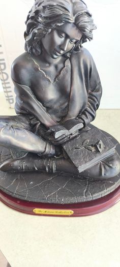 Bronze-toned sculpture of a woman reading, often titled -Reading Time Girl-  produced by The Milano Collection