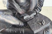 Bronze-toned sculpture of a woman reading, often titled -Reading Time Girl-  produced by The Milano Collection