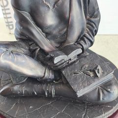 Bronze-toned sculpture of a woman reading, often titled -Reading Time Girl-  produced by The Milano Collection
