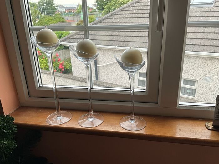 Set of 3 clear glass stemmed candle holders with ivory candles