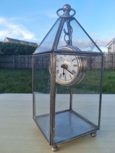 Table clock in a glass lantern.
