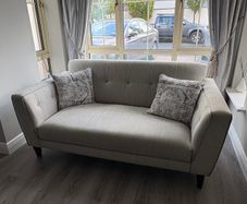 Modern two-seater sofa in light grey fabric
