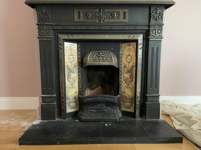 Late Victorian / early Edwardian style cast iron fireplace with tiled inserts and a decorative mantel surround