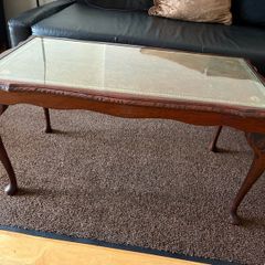 Vintage Queen Anne-style wooden coffee table featuring cabriole legs, a glass top protecting an inset leather surface with gold tooling
