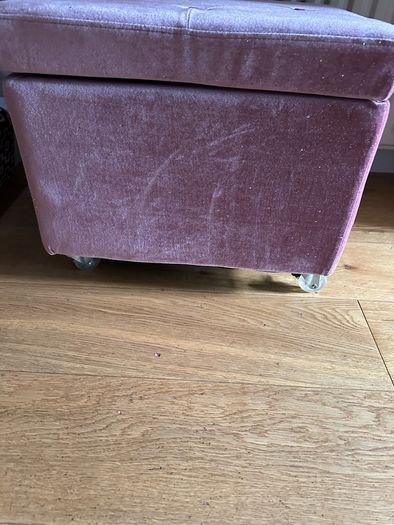 pink velour covered stool with interior storage space moves easily on castors