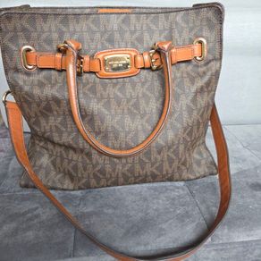 Michael Kors brown signature large handbag with shoulder strap. Spacious interior with multiple pockets. In perfect condition apart from one small tear, as shown in the photo.