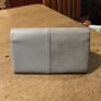 River Island clutch purse featuring a dual-texture gray flap panel design and a central dark metallic logo plate. Perfect inside. Image 3