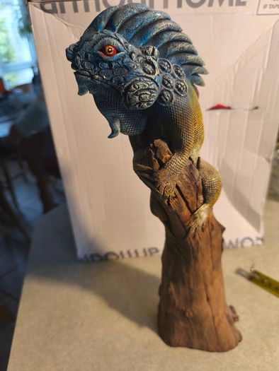 handmade iguana on natural wood log