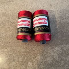 Two spools of red viscose knitting and crochet yarn