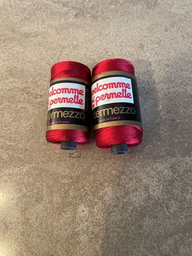 Two spools of red viscose knitting and crochet yarn