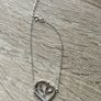 A silver bracelet with a heart-shaped pendant featuring a horse and foal's head. Image 8