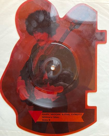 Rare and collectible Gary Moore and Phil Lynott special 2 in 1 shaped picture disc. Out in the fields and military man. Bought this new back in the day. Records were never played but picture disc discoloured over time as all versions did. Still highly col