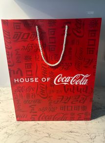 House of Coca-Cola Paper Gift Bag featuring white rope handles