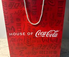 House of Coca-Cola Paper Gift Bag featuring white rope handles