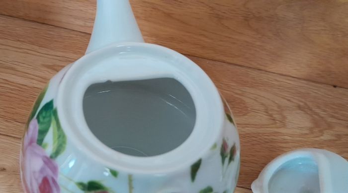 Tea for one: tea pot and cup with rose design on white