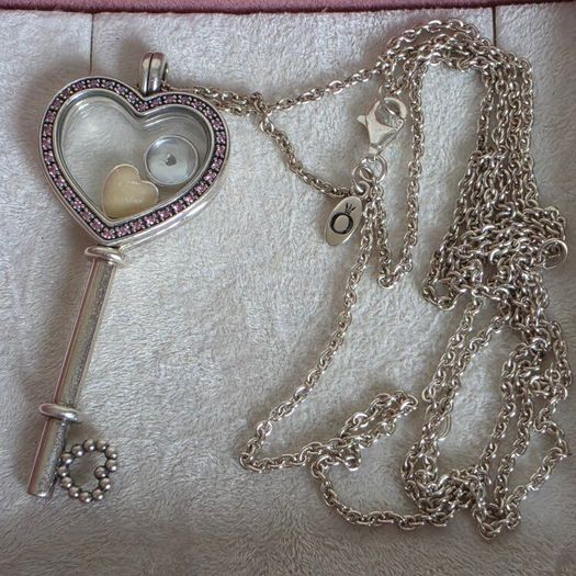 Pandora sterling silver key necklace with a heart,shaped floating locket and pink sparkling stones. Includes the two petite charms
