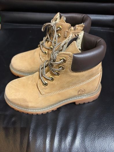 pair of tan/wheat leather boots with a padded dark brown collar.
