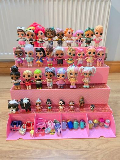 A lot of L.O.L. Surprise dolls with accessories and a doll podium.