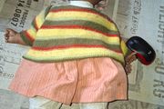 Vintage Beautiful Black Doll, late 20th century, wearing a striped knitted sweater and a peach-colored skirt, Measurements are in the photo's