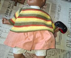 Vintage Beautiful Black Doll, late 20th century, wearing a striped knitted sweater and a peach-colored skirt, Measurements are in the photo's