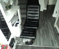 Black leather swivel chair with foot stool