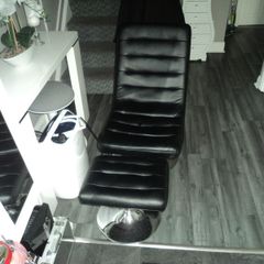Black leather swivel chair with foot stool