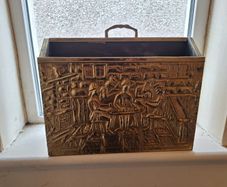 Vintage brass magazine rack with embossed tavern scene