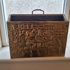 Vintage brass magazine rack with embossed tavern scene