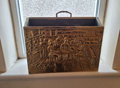 Vintage brass magazine rack with embossed tavern scene