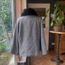black and white short jacket with detachable faux fur scarf detail and cape sleeves. Image 3