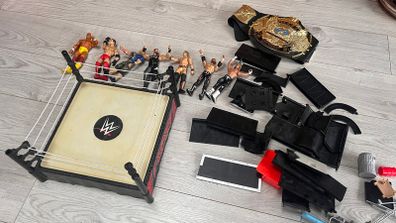WWE wrestling ring with figures and championship belt