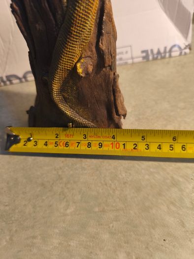 handmade iguana on natural wood log