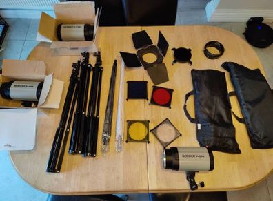 Neewer c-2.50 strobe lighting kit comprising off     3 strobes 2 soft boxes 2 umbrellas 1 barn doors 1 grid 3 stands and a set of four gels. All comes in a carry bag the bag isn't in great condition but could probably be fixed up a bit.
