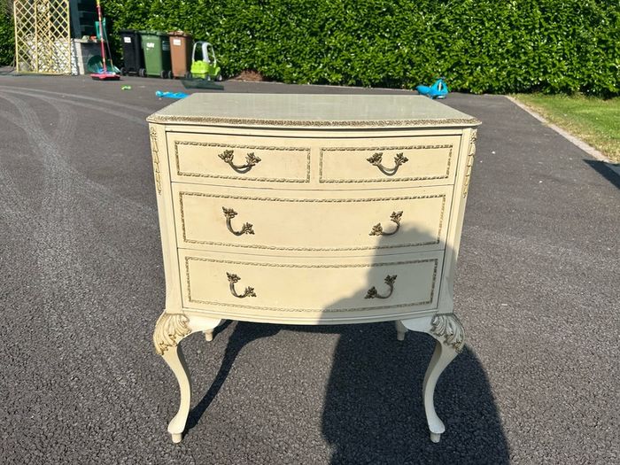 Vintage Olympus cream and gilt Louis style chest of drawers featuring bow-front drawers and cabriole legs.