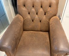 Pair of brown leather chesterfield armchairs