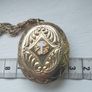 A large medallion featuring religious symbols, suspended from a long chain. Image 10