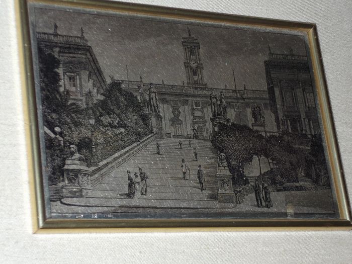 a picture with a silver plaque in the centre