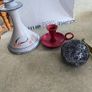 3 different itmes- 1- pottery modern design handmade candle holder 18.00 euro. 2-  red enamel candlestick holder and drip tray featuring a Considered by Helen James 12.00 euro. 3-  PAPERWEIGHT 15.00 euro Image 2