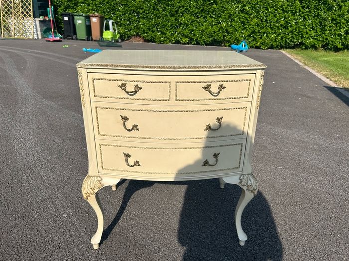 Vintage Olympus cream and gilt Louis style chest of drawers featuring bow-front drawers and cabriole legs.