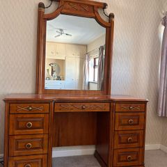 Crafted from stained hardwood with raised drawer panels, rounded pedestal edges, and an arched top mirror crown bordered by heavy metal or wood accent brackets. Nautical Rope Detailing: The upper accent panels on the mirror frame, the top left drawer, and