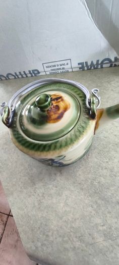 3 different items. No. 1- Mid-Century Porcelain Teapots, Japan, 1960.  95.00 euro. 2- VTG Hand Painted Le Poet Laval France Serving Plate 22.00 euro. 3- Vintage Short Dark Forest Green Ceramic 22.00 euro.
