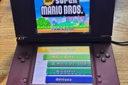 Nintendo DSi XL burgundy with Super Mario