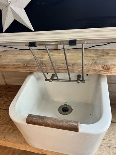 Heavy vintage ceramic basin with a built-in metal rack.