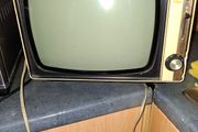 Ideal Prop, Vintage Working Boots Audio TV12 Portable Black and White CRT Television, featuring a cream plastic casing with side control dials and a 12 inch screen. Designed with dual power capabilities supporting standard mains voltage (240V) as well as 