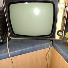 Ideal Prop, Vintage Working Boots Audio TV12 Portable Black and White CRT Television, featuring a cream plastic casing with side control dials and a 12 inch screen. Designed with dual power capabilities supporting standard mains voltage (240V) as well as 